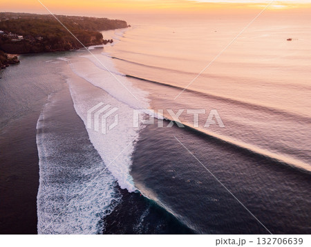 Aerial view of sunset and ocean with perfect surfing waves in Bali. Aerial view of sunset and ocean with perfect surfing waves in Bali. 132706639