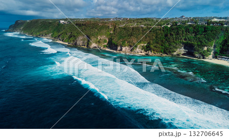 Tropical coastline with cliffs and blue ocean with waves in Bali. Aerial view Tropical coastline with cliffs and blue ocean with waves in Bali. Aerial view 132706645