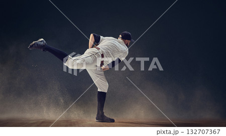 Baseball pitcher completing throw follow-through with dust swirling around showing momentum release 132707367