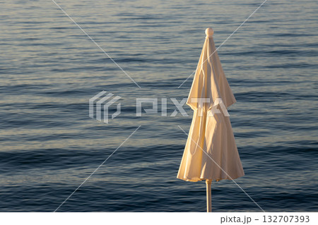 Closed beach umbrella and sea, Corfu (Korfu), Greece 132707393