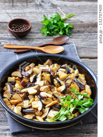 fried wild porcini mushrooms, ceps in a black bowl 132707400