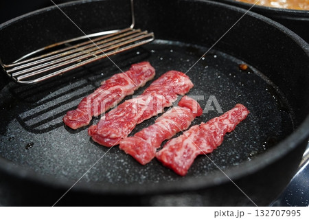 Raw Beef Strips Sizzling on a Grill Pan Raw Beef Strips Sizzling on a Grill Pan 132707995