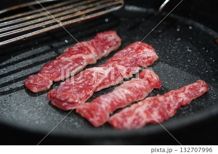 Raw Beef Strips Sizzling on a Grill Pan Raw Beef Strips Sizzling on a Grill Pan 132707996