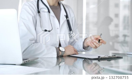 Doctor writing prescription or medical record, providing patient care and healthcare services in clinic. Medicine and health care 132708755