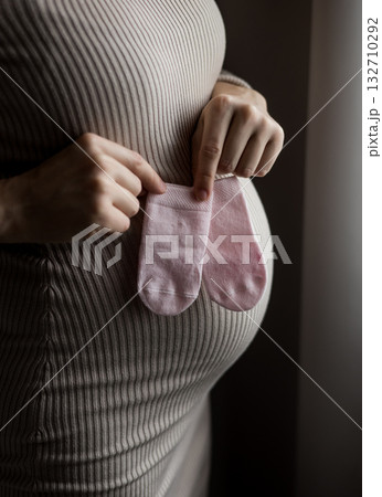 pregnant woman put little tiny socks on belly 132710292
