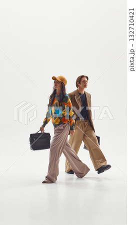Stylish man and woman walking together confidently symbolizing equality and ambition Stylish man and woman walking together confidently symbolizing equality and ambition 132710421