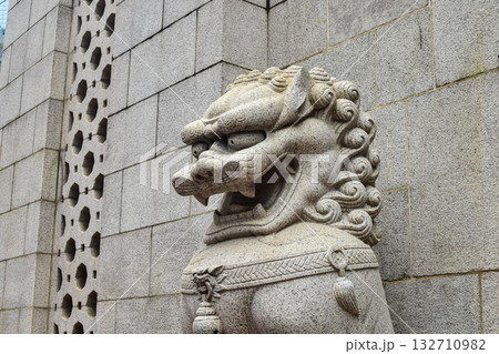 Chinese guardian lions, a stylized figure of a snarling lion. Traditional white stone Chinese lion statue at the entrance to Buddhist temple in Hong Kong city 132710982