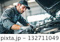 A car mechanic technician repairs a car in an auto repair shop. Generative AI. 132711049