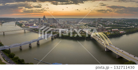 Cincinnati, Ohio with driving cars on bridge highway near illuminated high skyscraper buildings in downtown district in USA. American city with business financial district at sunset 132711430