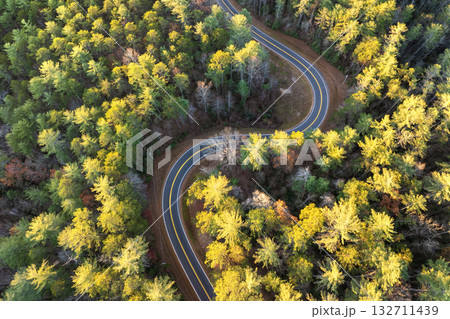 Car driving through colorful fall scenery in Appalachian region. Winding forest road surrounded by golden leaves and cool mountain air Car driving through colorful fall scenery in Appalachian region. Winding forest road surrounded by golden leaves and cool mountain air 132711439