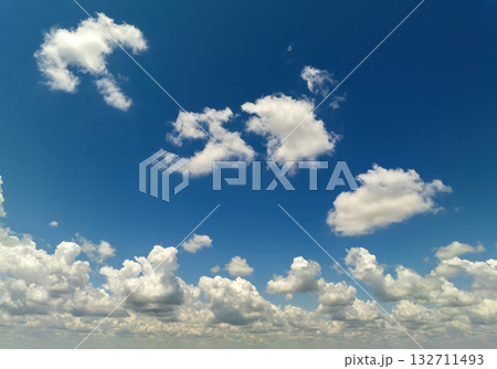Bright landscape of blue sky with flying white clouds. Colorful summer skyscape 132711493