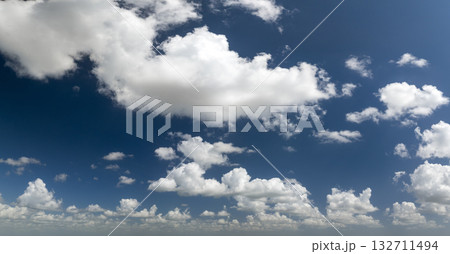 Bright landscape of blue sky with flying white clouds. Colorful summer skyscape 132711494