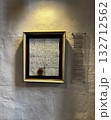 An illuminated framed medieval document with seal hangs on a textured wall in Osnabruk, supported by a modern explanation panel. 132712562