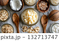 Jar of coconut oil sits on a table with other jars and spoons 132713747