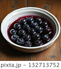Bowl of blueberries is sitting on a wooden table 132713752