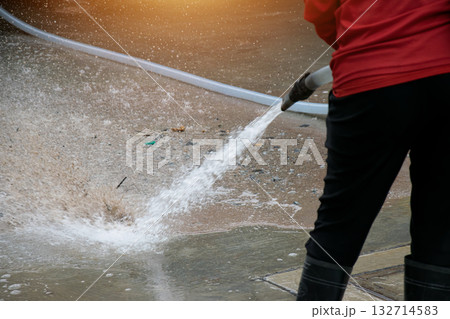 Workers are using water to wash the road surface. Workers are using water to wash the road surface. 132714583