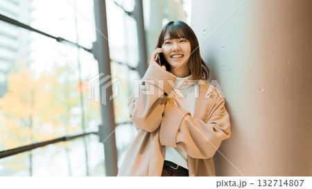 スマートフォンで通話をするコートを着た女性 132714807