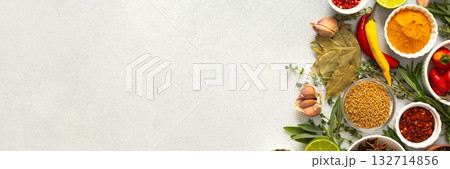 A mix of dried herbs and spices laid out on a gray background, highlighting natural flavors and culinary essentials, top view and copy space, banner A mix of dried herbs and spices laid out on a gray background, highlighting natural flavors and culinary essentials, top view and copy space, banner 132714856