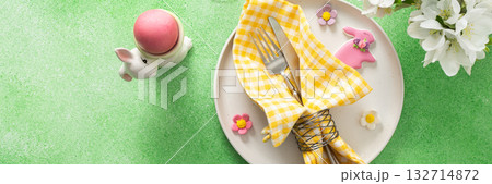 A vibrant Easter table setting features yellow checkered napkins wrapped with twine, a decorative plate, and fresh flowers, creating a festive atmosphere for spring gatherings, banner A vibrant Easter table setting features yellow checkered napkins wrapped with twine, a decorative plate, and fresh flowers, creating a festive atmosphere for spring gatherings, banner 132714872