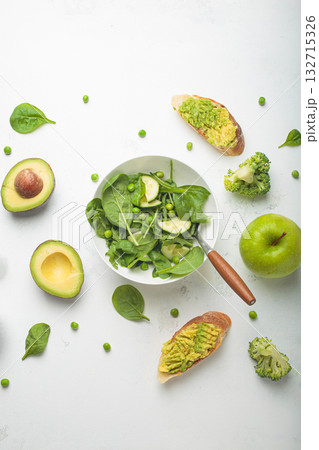 Fresh salad bowl, avocado toasts, raw green vegetables fruit white background top view, diet, vegetarian healthy food Fresh salad bowl, avocado toasts, raw green vegetables fruit white background top view, diet, vegetarian healthy food 132715326