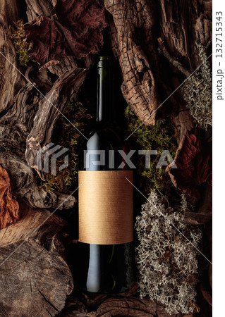 Bottle of red wine against a backdrop of moss and dry driftwoods. 132715343