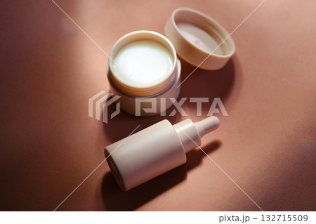 Face cream and serum on a soft beige background. Face cream and serum on a soft beige background. 132715509