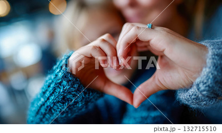 Close-up of two hands forming a heart shape, expressing love, connection, and family warmth 132715510