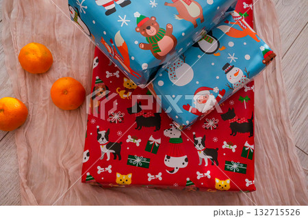 Two wrapped Christmas gift boxes paired with fresh tangerines, creating a cheerful festive composition. Perfect for holiday, Christmas, and winter-themed projects. Two wrapped Christmas gift boxes paired with fresh tangerines, creating a cheerful festive composition. Perfect for holiday, Christmas, and winter-themed projects. 132715526