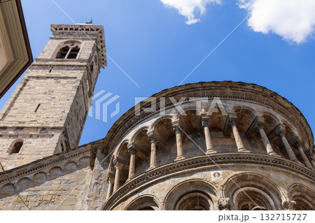Bell tower and apse of Saint Mary Major showing Romanesque stonework arches under blue sky 132715727