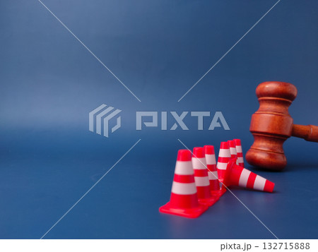 The combination of a gavel and traffic cones can symbolize legal obstacles or the law creating barriers. The combination of a gavel and traffic cones can symbolize legal obstacles or the law creating barriers. 132715888