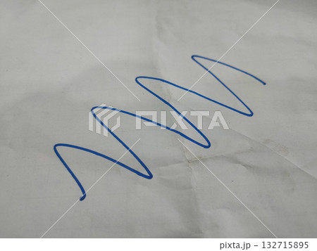The image shows a blue, continuous, wavy line drawn on a piece of white paper. The image shows a blue, continuous, wavy line drawn on a piece of white paper. 132715895