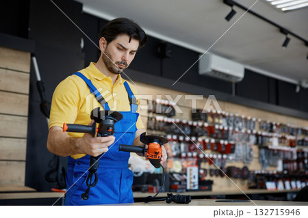 A man working on a grinding machine in a store A man working on a grinding machine in a store 132715946