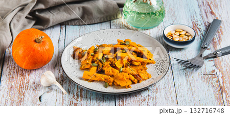 Spicy salad with fried pumpkin, garlic and herbs on a plate on the table web banner Spicy salad with fried pumpkin, garlic and herbs on a plate on the table web banner 132716748