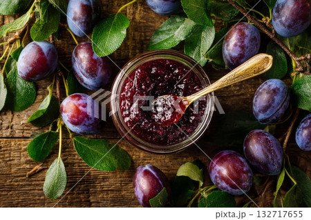 Homemade Plum Jam in a Glass Jar With Fresh Plums and Leaves on a Wooden Background 132717655