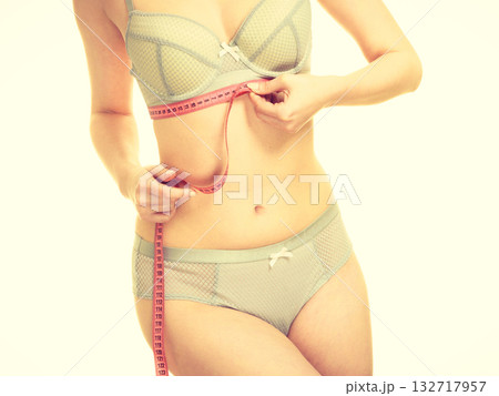 Woman in bra lingerie measuring her chest breasts. 132717957