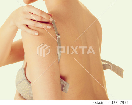 Attractive slim woman taking off grey bra 132717976