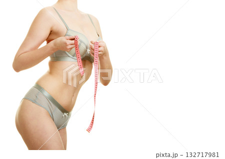 Woman measuring her under breasts. Woman measuring her under breasts. 132717981