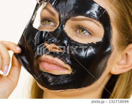 Girl removes black mask from face 132718094