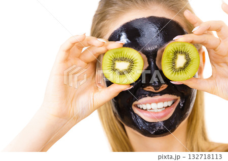 Girl black mask on face holds kiwi fruit 132718113