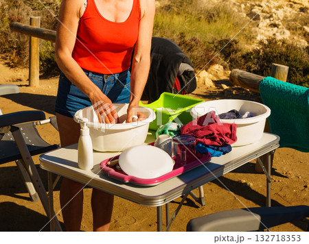 Woman washing dishes in bowl, capming outdoor Woman washing dishes in bowl, capming outdoor 132718353