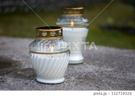 Memorial Candles. Two memorial candles with golden lids on a stone surface 132719328