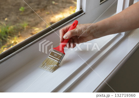 Old house renovation, woman painting window 132719360