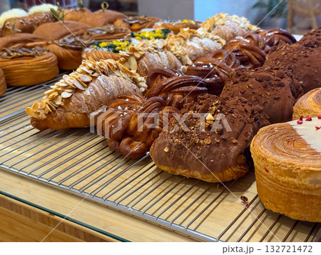 Variety of croissants and chocolate pastries on bakery display. Artisan craftsmanship and morning indulgence 132721472