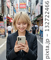 街中でスマートフォンを操作する金髪の女性 132722466