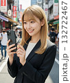 街中でスマートフォンを操作する金髪の女性 132722467