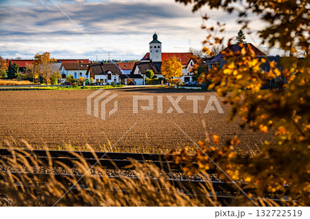 Church In Gilching, Bavaria: Picturesque Autumn Village Landscape With Colorful Trees, Golden Fields, And Dramatic Sky Near Munich 132722519