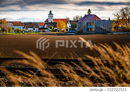 Church In Gilching, Bavaria: Picturesque Autumn Village Landscape With Colorful Trees, Golden Fields, And Dramatic Sky Near Munich 132722521