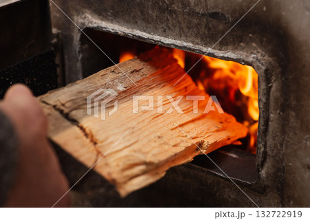 Heating the house in winter by burning firewood in solid fuel boiler. Cold season of the year, getting warm at home, no gas and electricity 132722919