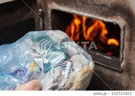 Burning garbage in solid fuel boiler. Heating the house, creating smog and toxic substances in the air, harmful for nature Burning garbage in solid fuel boiler. Heating the house, creating smog and toxic substances in the air, harmful for nature 132722923