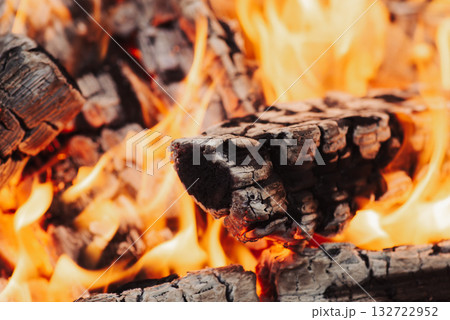 Close up of burning woods and bright orange flames. Fire, warmth, high temperature and cozy atmosphere concept Close up of burning woods and bright orange flames. Fire, warmth, high temperature and cozy atmosphere concept 132722952